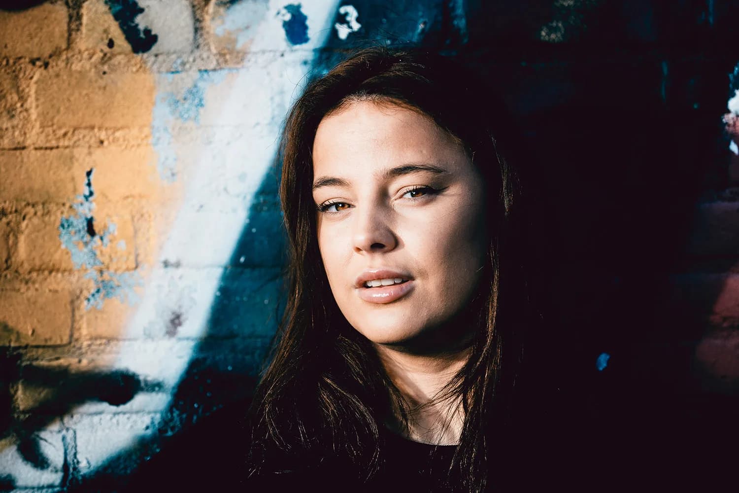 Portret van een vrouw voor een muur met blauwe verf