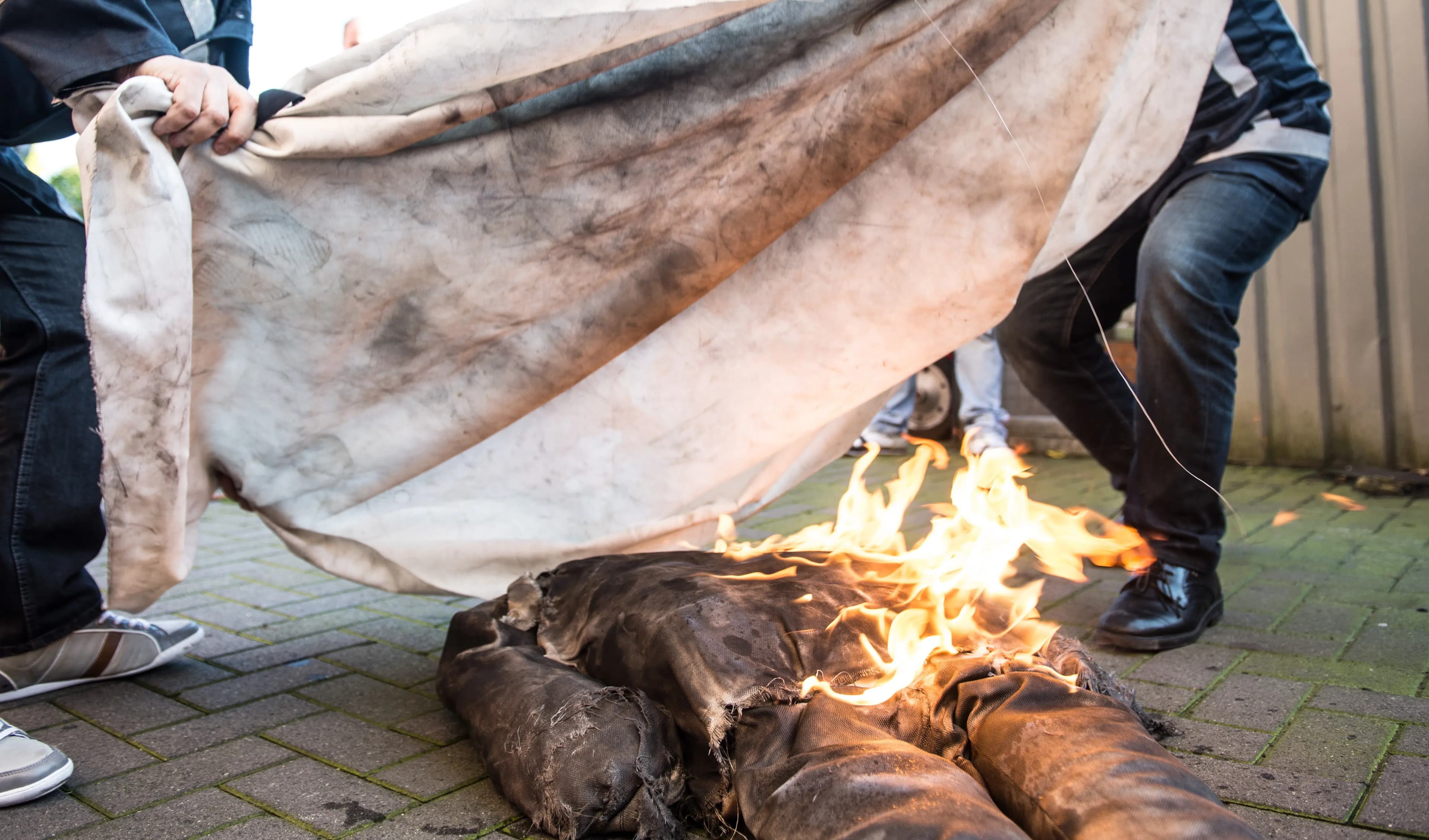 Een blusdeken wordt over brandende kleding gelegd tijdens een blusdemonstratie