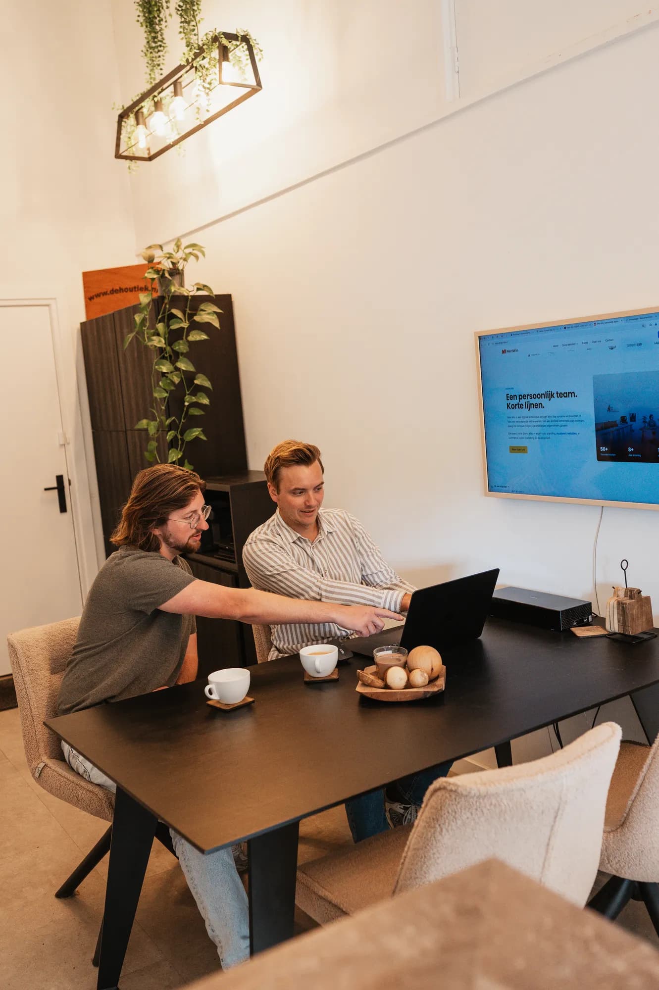 Gerwin wijst iets aan op de laptop, Pascal kijkt mee