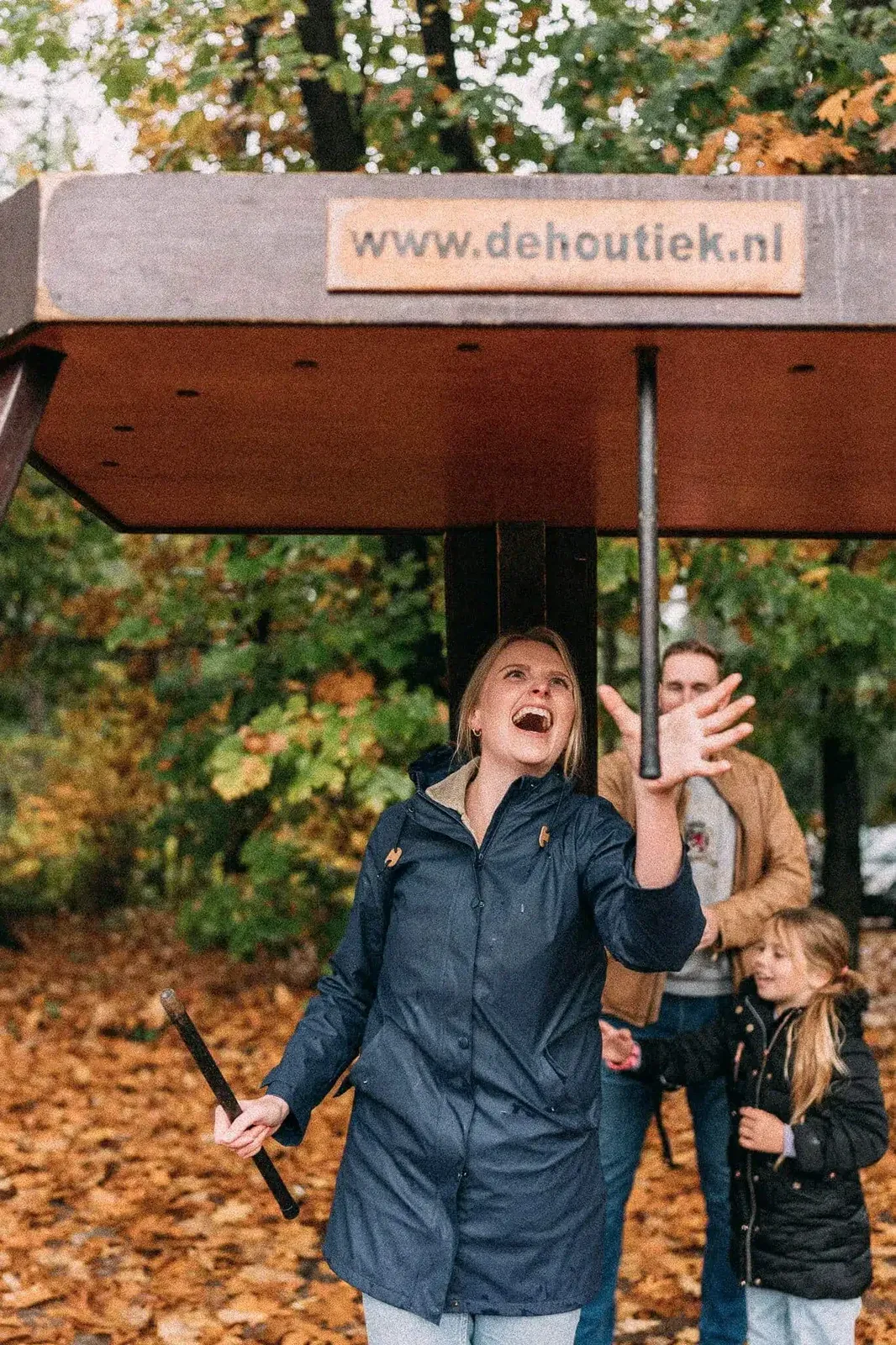 Een vrouw lacht terwijl ze een vallende stok grijpt bij stokvangen