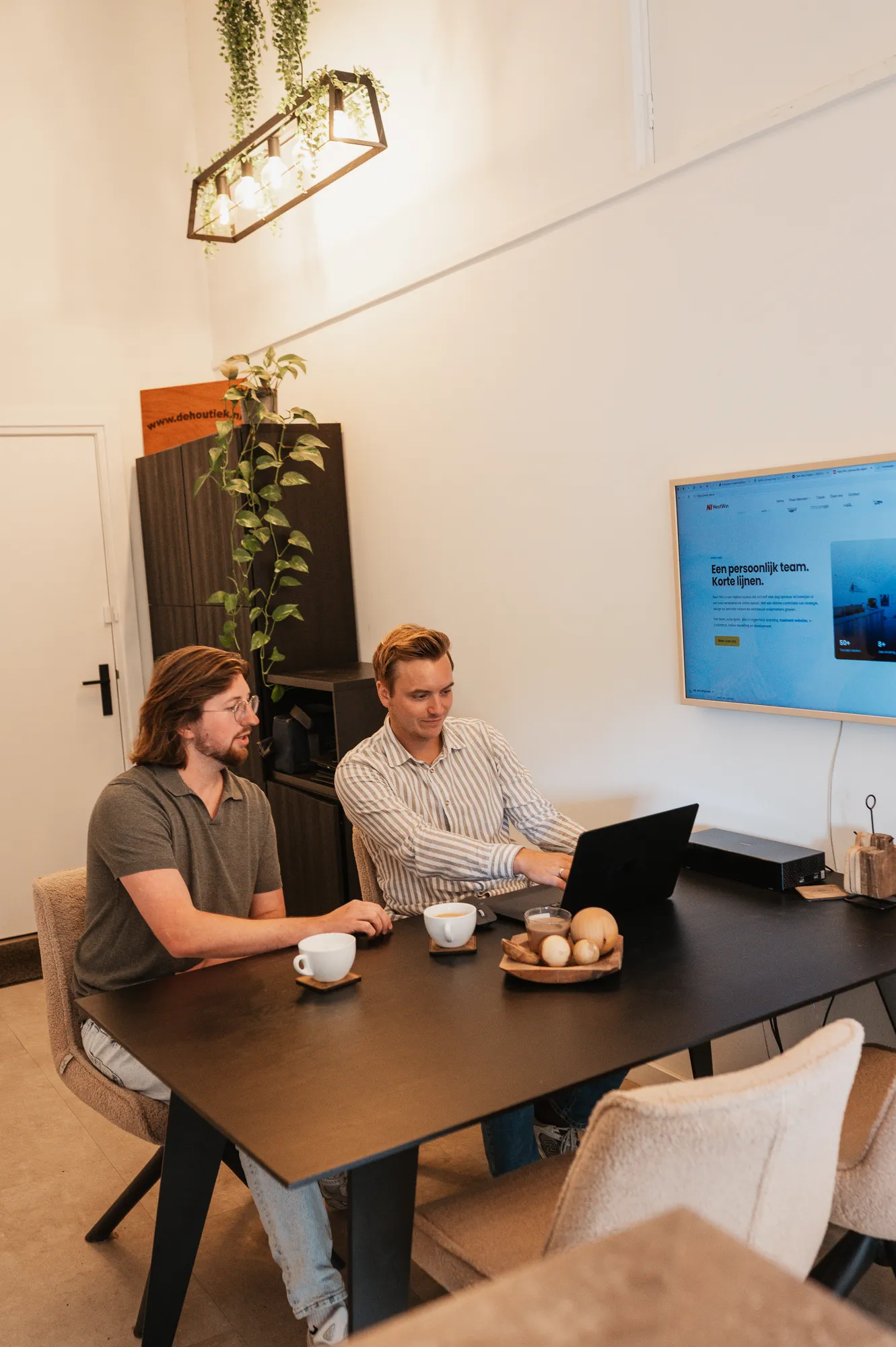 Pascal en Gerwin van Next Win samen achter een laptop aan tafel in Otterlo